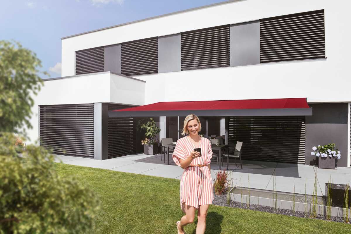 Moderne Terrasse mit rotem Sonnenschutz und stilvoller Einrichtung