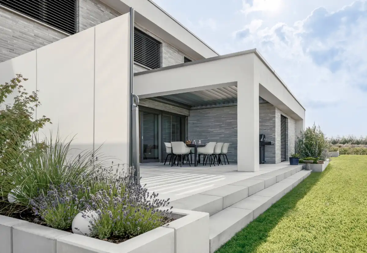 Lamellendach mit Fassadenanschluss Moderne Terrasse mit Garten und Lamellendach